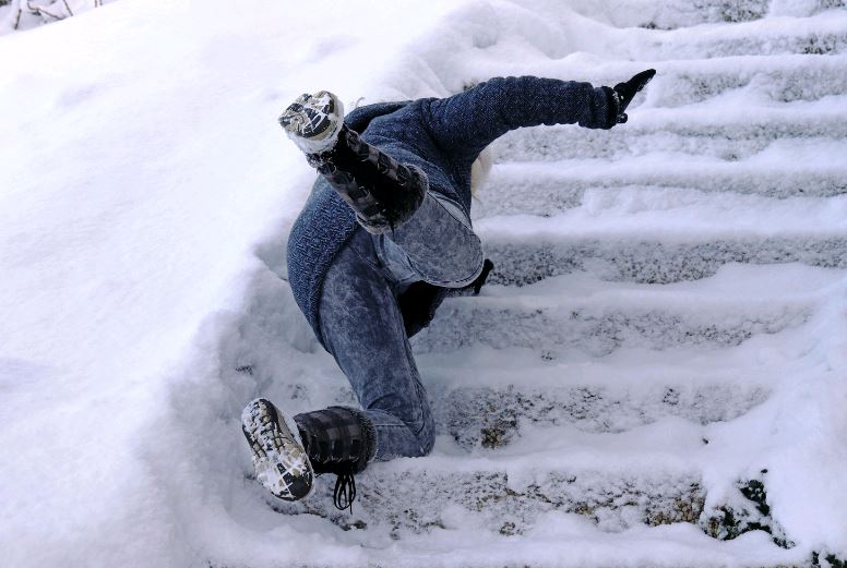 Person slipping and falling on snow covered stairs